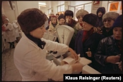 Coadă la carne într-o „Alimentara”, nume dat în comunism tuturor magazinelor în care se vindeau alimente. Fotografia, relevantă pentru anii '80 a fost făcută pe 30 decembrie 1989, în condițiile în care noile autorități au oprit imediat exporturile de mâncare și medicamente.