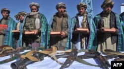 Сүрөттө: "Талибан" кыймылынын мурдагы мучөлөрү куралдарын таштап, Куранга кол коюп, ант беришүүдө