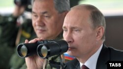 Президент Росії Володимир Путін та міністр оборони Сергій Шойгу (позаду)