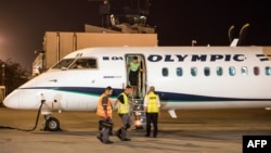A crew member opens the door of a Greek airliner in Skopje airport on November 1 after the first direct flight between Athens and the Macedonian capital in 12 years. 