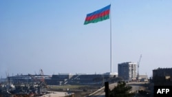 Azerbaijan -- An enormous Azerbaijani flag flies above the construction site of the 2012 Eurovision concert hall on the Caspian Sea shoreline in Baku, 14Jan2012