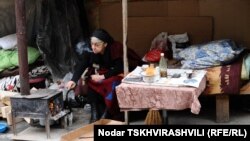 В Александровском парке в Тбилиси на большом пне – кастрюля с лобио и буханка хлеба, два молодых человека и пожилая женщина расположились на скамье. Неподалеку стоит большая палатка, которая и стала родным домом для этих людей