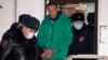 Aleksei Navalny is escorted out of a police station on January 18 in Khimki, outside Moscow.