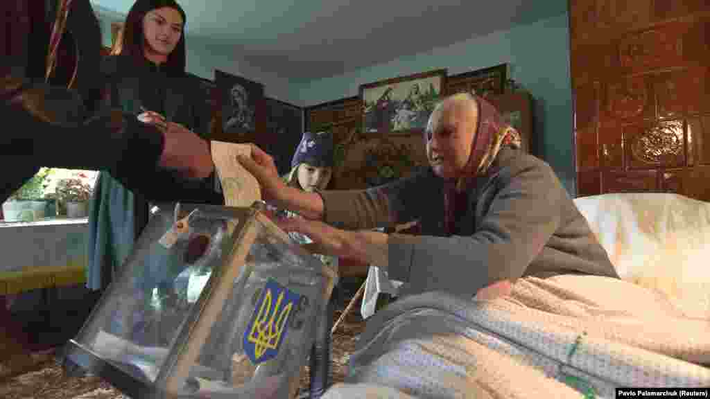 Lvov vilâyetiniñ Maydan köyünde yerli sakin köçme rey berüv qutusına bülletenni ata