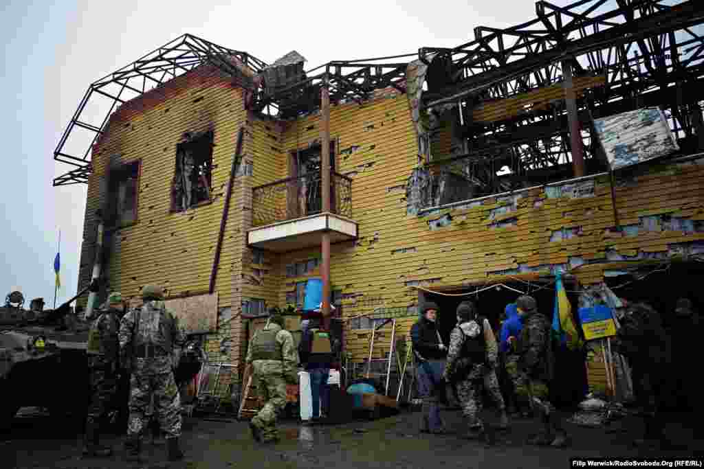 Група військових стоїть біля &laquo;Позиції 18&raquo;. Ця будівля, що розташована на передовій, перебуває під постійними обстрілами останні декілька місяців