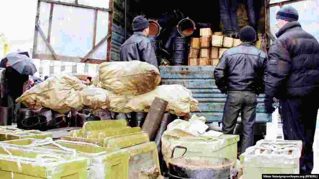 Faaller urbanen çuvallarnıñ ve azıq mallarınen qutularnı maşnadan çıqara.