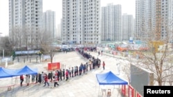 Кытайдагы вакцина алуу учурунан тартылган сүрөт.