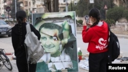 Cириялык кыздар президент Башар Асаддын сынык портретин сүрөткө тартып алууда,  8-декабрь, 2024-жыл 