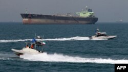 Ирандын революциячыл гвардиясынын кайыктары мунай тарткан кеменин маңдайында күзөттө жүрүшөт. Бендер-Аббас порту. 2-июль 2012