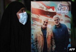 Касем Сулеймани менен Абу Хамид ал-Мухандистин сүрөтүн кармап турган аял. Багдад. 2-январь, 2021-жыл
