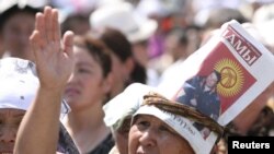 Ош мэринин сүрөтү бар баракчаны башына байлаган аял, 2010-жылдын, 20-августу, Оштогу митингден көрүнүш.