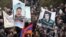 Armenia -- Demonstrators hold up pictures of jailed opposition members Aram Bareghamian (R) and Sasun Mikaelian, 1Mar2011.