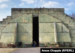 Двое летчиков-любителей сдерживают бронированную дверь после того, как они открыли ангар для самолетов на аэродроме Миловице