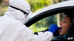 آرشیف، کارکن صحی برای آزمایش ویروس کرونا نمونه گیری می‌کند.