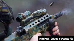 A member of Ukraine's special forces tests his weapon prior to a mission in the Bakhmut region on April 6. 