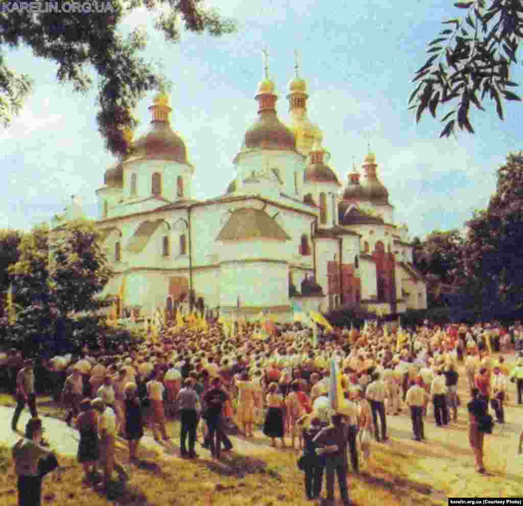 АРХІВНЕ ФОТО. Піднятий над Київрадою прапор перед цим освятив у Софії Київській майбутній патріарх, а тоді архімандрит Української автокефальної православної церкви Володимир (Романюк) за участі священників УАПЦ і УГКЦ. Київ. 24 липня 1990 року