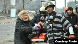 Розстріли на Майдані у Києві 20 лютого 2014 року. Марія Матвіїв намагається врятувати пораненого 19-річного студента Романа Гурника