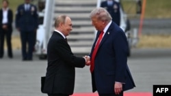 Президент США Дональд Трамп (справа) приветствует президента России Владимира Путина на взлетно-посадочной полосе после их прибытия на объединенную базу Элмендорф-Ричардсон в Анкоридже, Аляска, 15 августа 2025 года