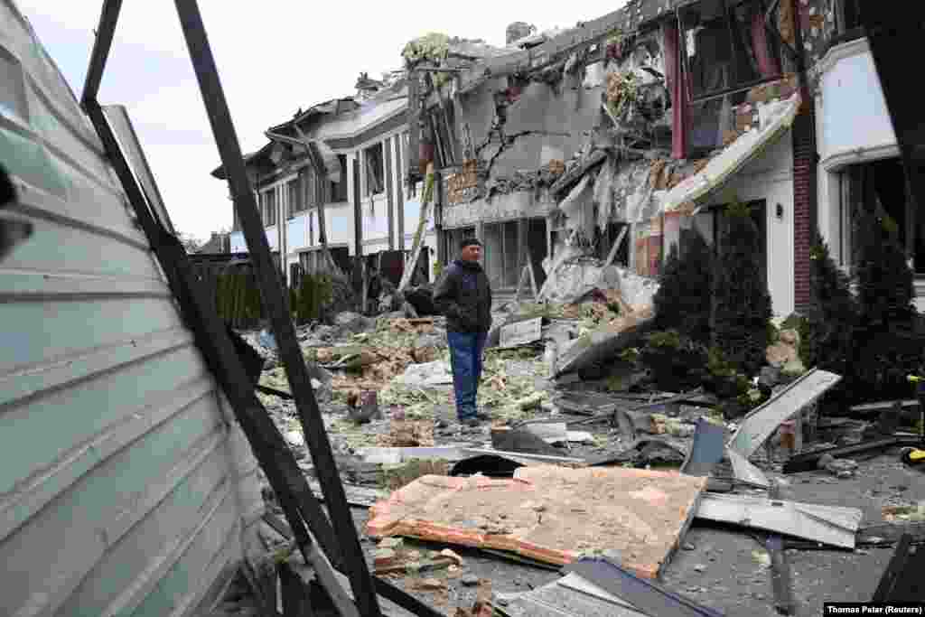 Чоловік стоїть серед уламків та руйнувань внаслідок російської атаки столицю