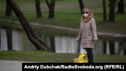 Жінка у медичній масці у парку та Троєщині в Києві, 24 квітня 2020 року