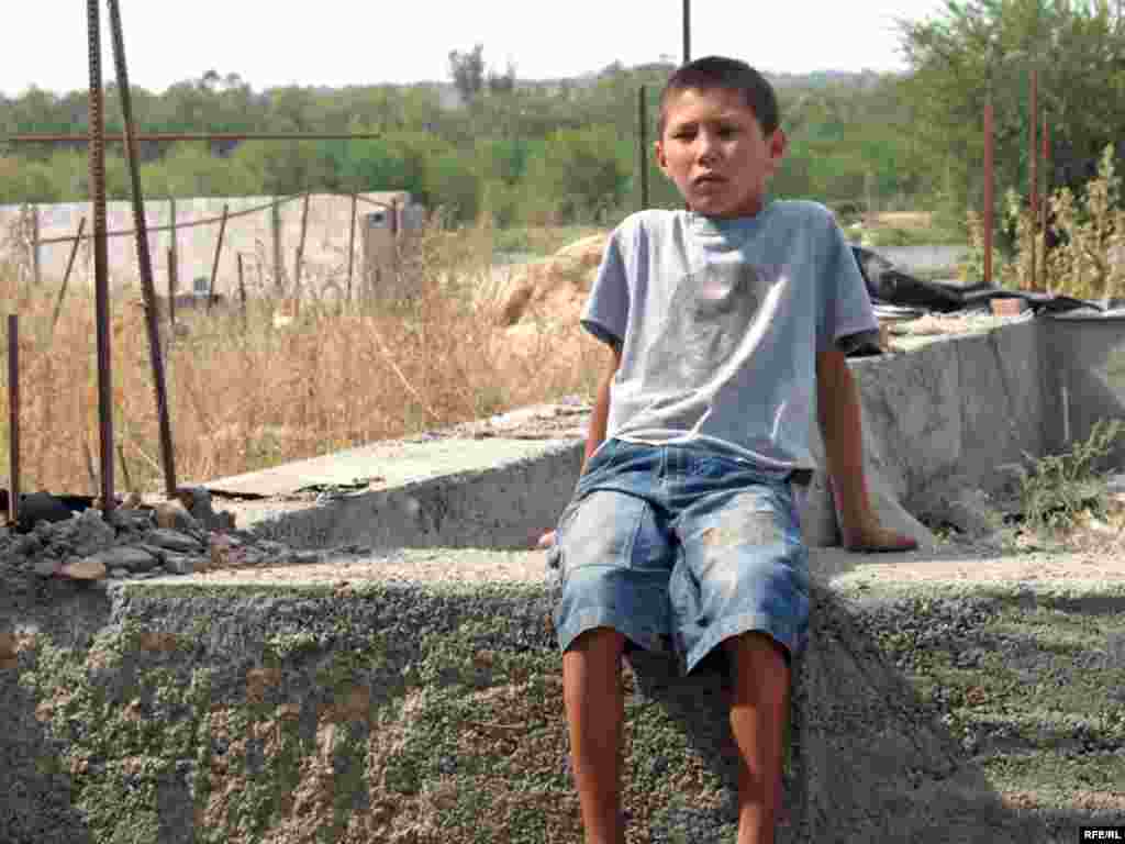  Мальчик Санжар сидит на руинах дома, где жила его бабушка. Микрорайон Красный Трудовик, 16 сентября 2008 года.  -  Мальчик Санжар сидит на руинах дома, где жила его бабушка. Микрорайон Красный Трудовик, 16 сентября 2008 года. 