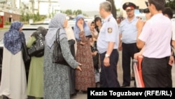 Полицейские не допускают к зданию прокуратуры жен узбекских беженцев-мусульман. Алматы, 9 июня 2011 года.  