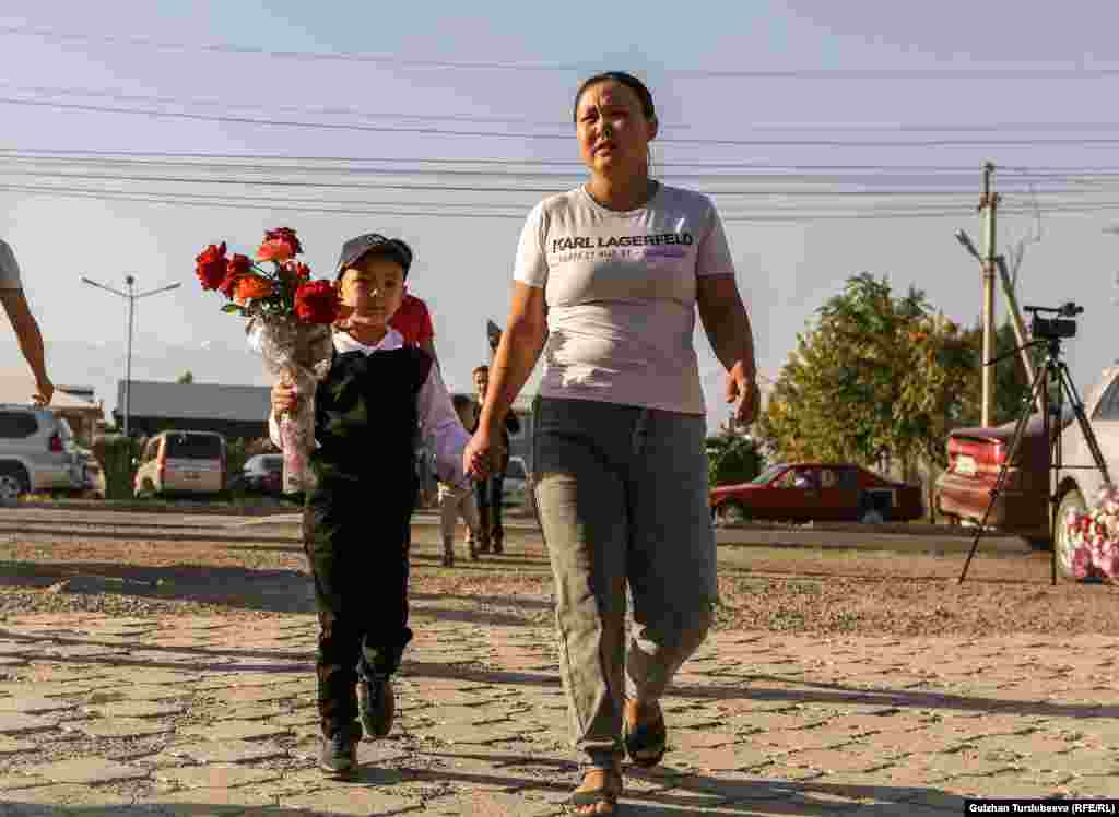 Мектепке келе жаткан эне жана бала.