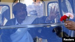 Сторонники Муамара Каддафи встречают его цветами...