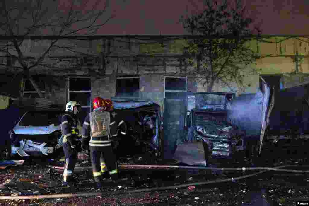 Пожарные стоят возле сгоревших автомобилей на месте удара российского беспилотника, Украина, 8 ноября 2025 года. REUTERS/Thomas Peter
