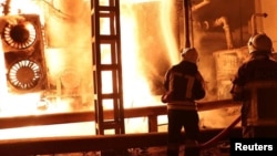 Firefighters work to put out a fire at an energy infrastructure facility damaged by a Russian drone strike at an undisclosed location in Ukraine on October 27.