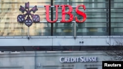 Швейцариянын Цюрих шаарынын көчөлөрүндөгү UBS жана Credit Suisse банктарынын эн белгилери. 20-март, 2023-жыл. REUTERS/ Денис Балибоус. 
