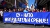 Far-right protesters in Belgrade commemorate the NATO strikes in Serbia, walking behind a sign that reads "EU + NATO, Our Enemies," on March 24.