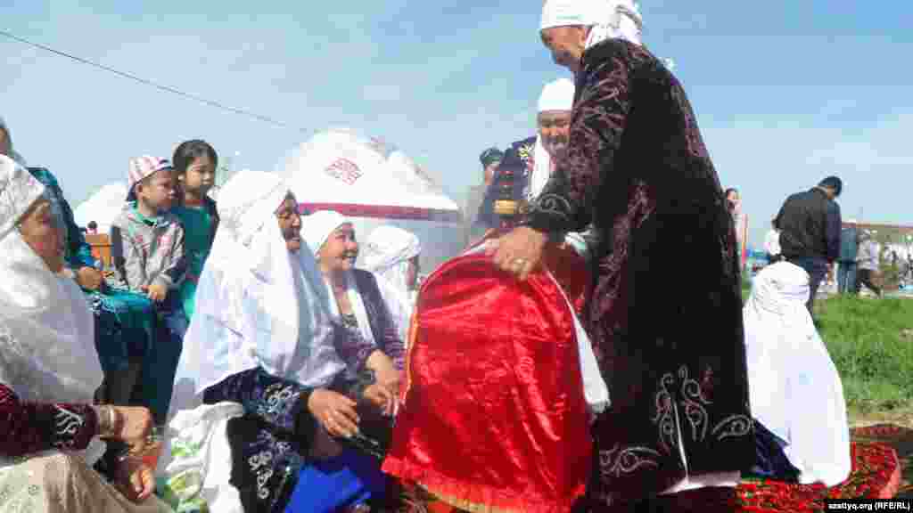 Женщины укрошают деревянную колыбельную.