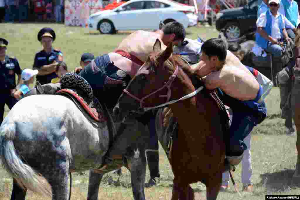Момент поединка борцов на лошадях.
