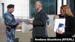 Сотрудник полиции просит гражданского активиста Руслана Оздоева покинуть территорию  сената парламента. Астана, 24 сентября 2012 года.