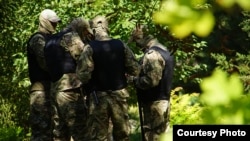 Rusiye uquq qoruyıcıları Moskva kontrolindeki Aqmescitniñ Kiyev rayon mahkemesi ögünde. Nümüneviy fotoresim