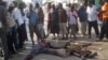 Жители сомалийского города Могадишо стоят возле тел двух погибших горожан. Иллюстративное фото.       