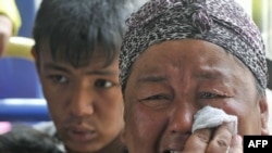 Etniki özbek zenan awtobus arkaly Oşdan çykyp barýar, 2010-njy ýylyň 15-nji iýuny. 