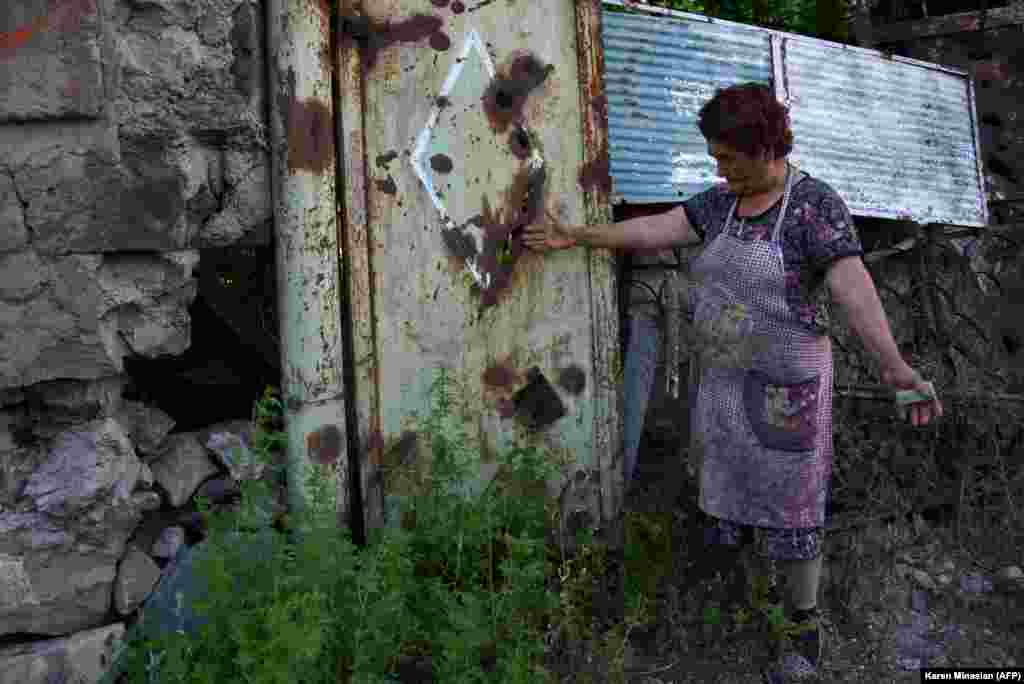 Жінка на своєму подвір&#39;ї показує сліди від обстрілу. Село Айгепар, Вірменія&nbsp;