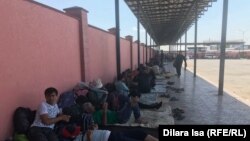 Қазақ-өзбек шекарасындағы "Жібек жолы" бекетіндегі автовокзалды отырған тәжік мигранттары. Түркістан облысы, Сарыағаш ауданы, 2 маусым 2020 жыл.
