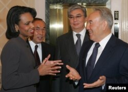 Президент Казахстана Нурсултан Назарбаев (справа) встречается с госсекретарем США Кондолизой Райс, на втором плане: посол Казахстана в США Канат Саудабаев (второй слева) и министр иностранных дел Касым-Жомарт Токаев. Астана, 13 октября 2005 года.