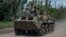 Ukrainian soldiers ride an armored vehicle on the front line near Bakhmut in the Donbas. 
