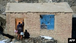 An Afghan health worker marks a door in Kabul to denote that it's been visited by a polio-eradication team on the last day of a vaccination campaign in February.