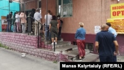 Люди стоят в очереди за лекарствами у аптечного склада, Алматы, 1 июля 2020 года.