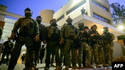 د امریکا فېډرالي او د کورني امنیت وزارت سرتېري د اورېګان ایالت په پورټلینډ کې د کډوالۍ او ګمرکي چارو ادارې ودانۍ مخې ته ولاړ دي - د اکتوبر شپږمې انځور. 