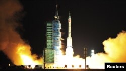 A modified model of the Long March CZ-2F rocket carrying an unmanned spacecraft blasts off from the launch pad at the Jiuquan Satellite Launch Center in northwest Gansu Province.