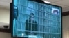 Pavel Ustinov appears on a video monitor during his hearing in a Moscow courtroom on September 20. 