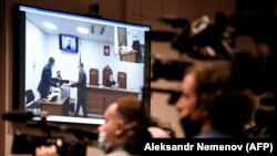 Соттун жүрүшүнө көз салып турган журналисттер.