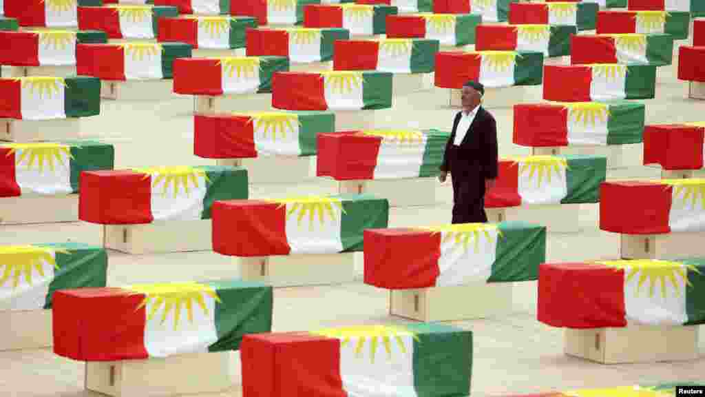 Курд проходит между гробами с останками более 700 курдов - жертв режима Саддама Хусейна - во время церемонии перезахоронения в Сулеймании, в 260 километрах от Багдада, 28 мая. По данным правозащитных организаций, около 180 тысяч курдов погибли в результате операции, которую режим Саддама Хусейна начал в 1988 году. (Reuters)