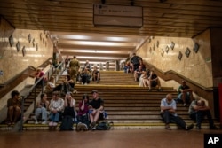 Людзі ў Кіеве хаваюцца ад расейскай атакі ў пераходзе мэтро. 6 чэрвеня 2025 году